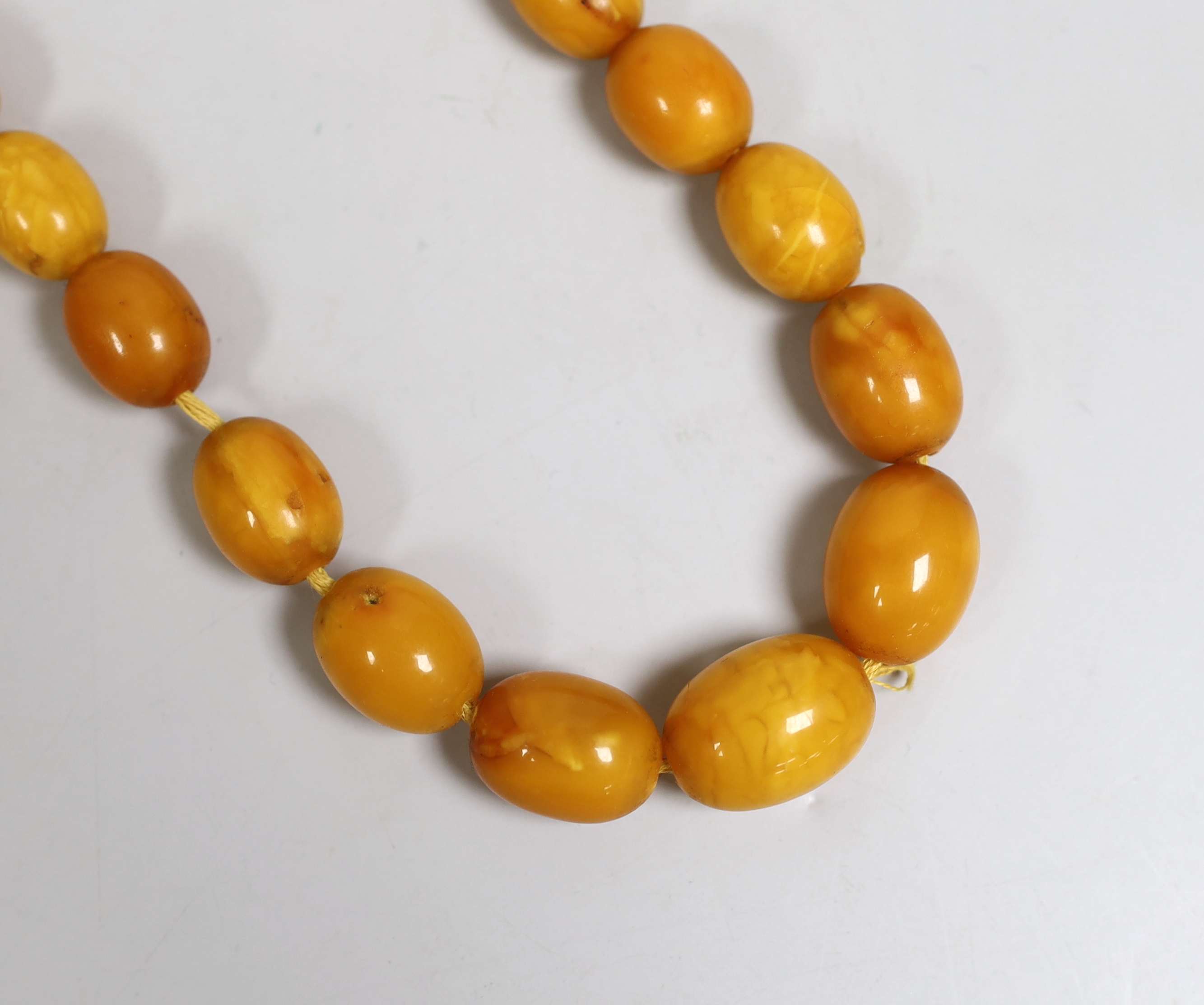 A single strand graduated oval amber bead necklace, 46cm, gross 51 grams.